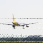 Die etwas andere Perspektive beim Flugzeuge beobachten eine Maschine hinter dem Stacheldrahtzaun