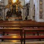 Eine Bankreihe und ein kleiner Altar im Petersdom Rom