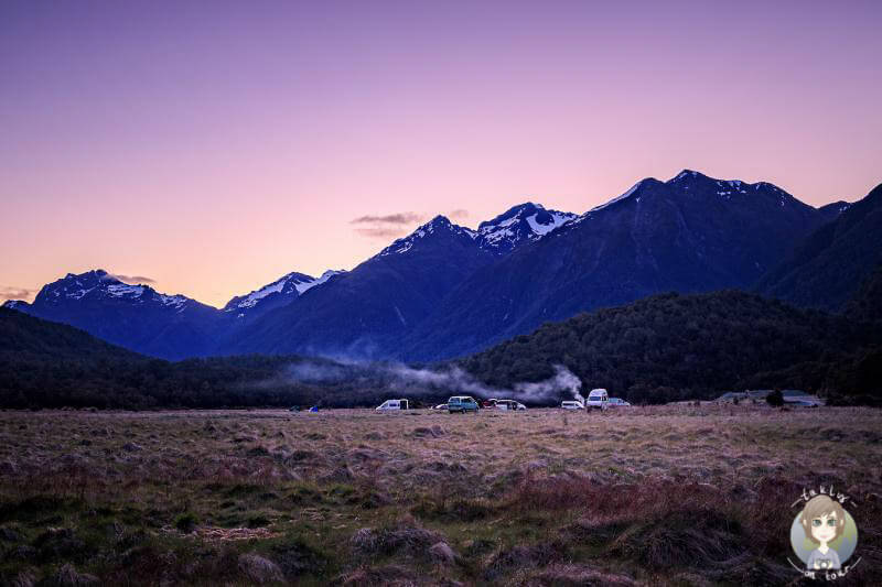 Sonnenuntergang auf dem Cascade Creek Campground mit Blick auf die Berge ist einer der beliebtesten Campingplaetze in Neuseeland entlag der Milford Road