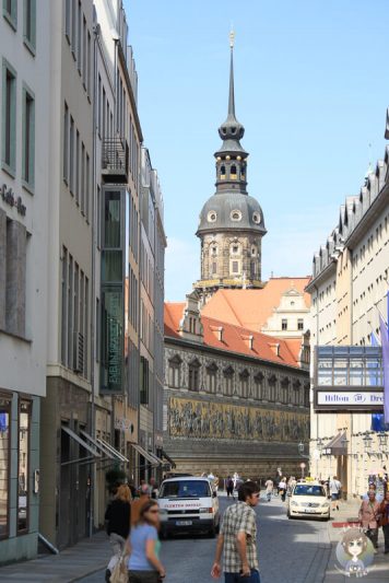 Blick auf ein Gebaeude in Dresden mit schoener Wandbemalung und ein Kirchturm im Hintergrund