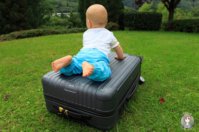 Ein Baby auf einem Koffer bereit zum Reisen in der Elternzeit