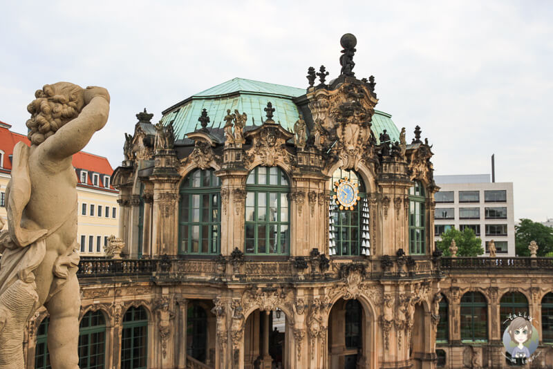 Eine Statue steht links und schaut auf das Gebäude des Zwingers Dresden