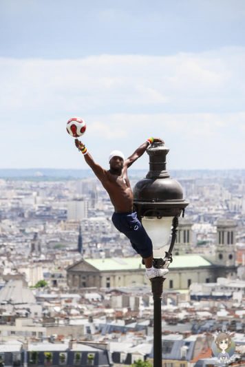 Ein Akrobat mit einem Ball auf einer Strassenlaterne