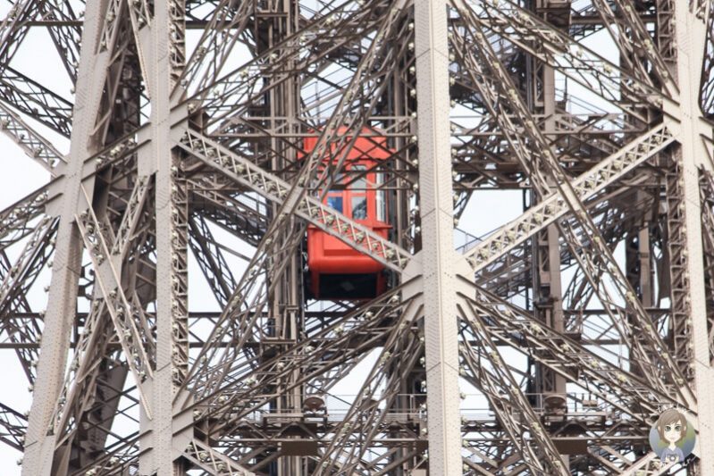 Ein roter Aufzug zwischen den Streben des Eifelturms