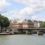 Blick über den Fluss Seine in Paris mit einer Bruecke im Hintergrund