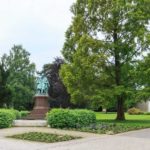 Blick durch den Haupteingang in den Schlosspark auf das Denkmal und den Springbrunnen