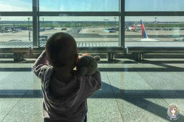 Ein Kind mit Teddy am Flughafen vor unserem ersten Mal Fliegen mit Kleinkind