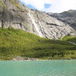 Der Briksdalsvatn mit einem Wasserfall im Hintergrund in Norwegen