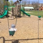 Ein Kind schaukelt auf einem Spielplatz